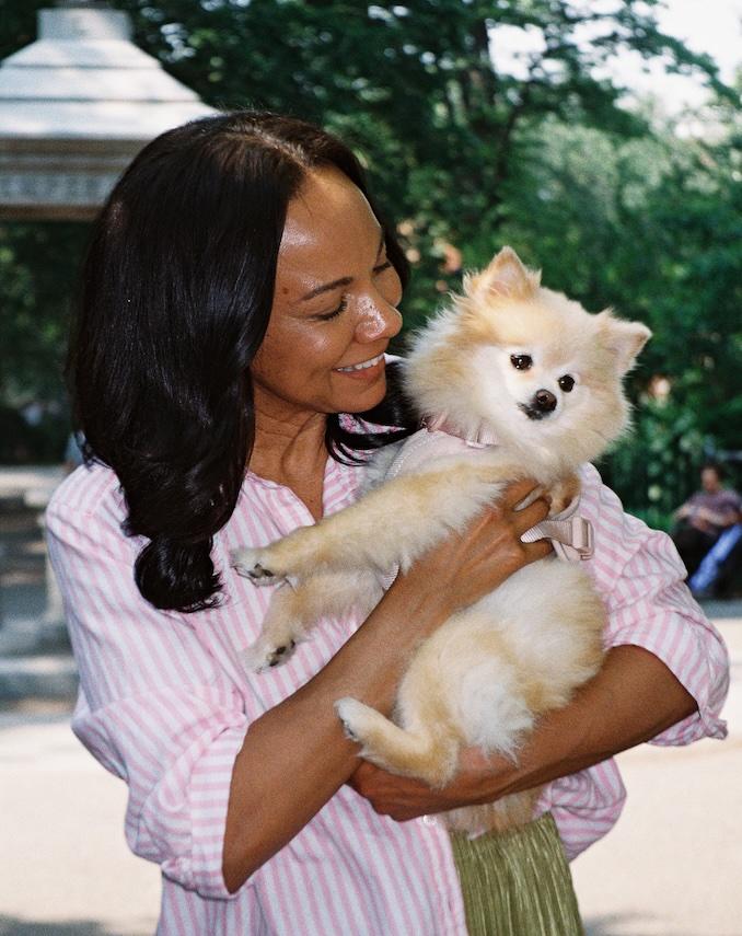 一名女士在戶外抱著一隻毛茸茸的小狗